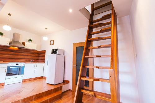 a kitchen with a wooden ladder in a room at Apartmány Elzet in Třeboň