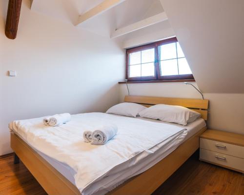 a bedroom with a bed with towels on it at Apartmány Elzet in Třeboň