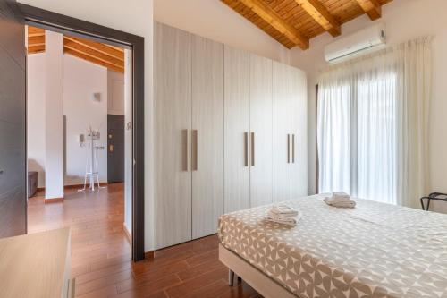 ein Schlafzimmer mit einem Bett und einem großen Fenster in der Unterkunft SAVOIA 173 - Apartment in Acireale