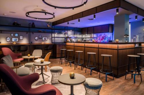 a restaurant with tables and chairs and a bar at Best Western Premier Alsterkrug Hotel in Hamburg