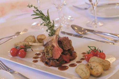 a plate of food with meat and potatoes on a table at Best Western Premier Alsterkrug Hotel in Hamburg