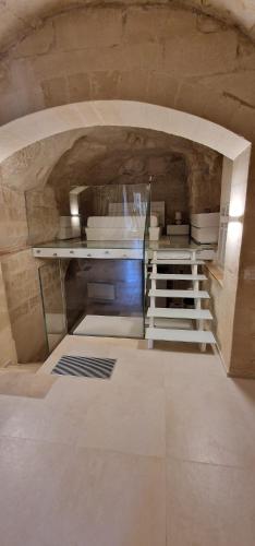 a kitchen with a staircase in a stone building at Casa Grotta Francy - Piazza San Giovanni in Matera