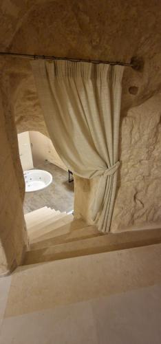 a room with a curtain in a stone wall at Casa Grotta Francy - Piazza San Giovanni in Matera