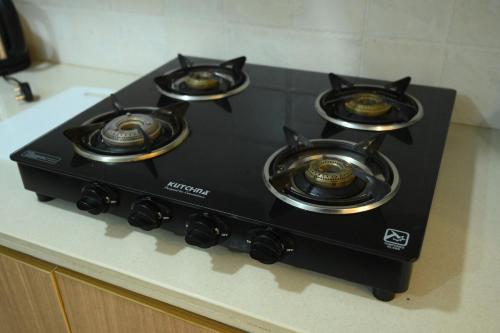 a black stove with four burners on a counter at 2 BHK The Luxury Stays by Glambirds Apartment in Solan