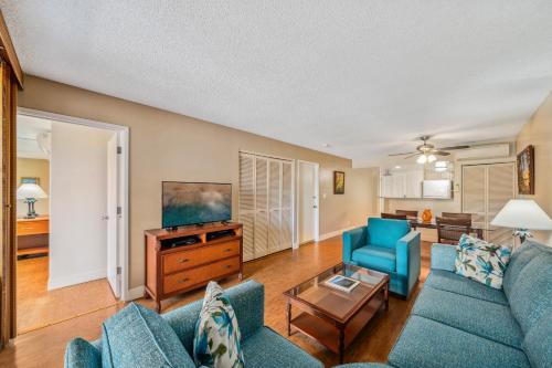 a living room with a couch and a tv at Kahana Falls Resort in Honokowai