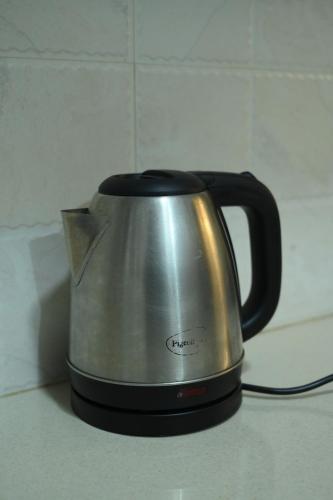 a tea kettle is sitting on a kitchen counter at 2 BHK The Luxury Stays by Glambirds Apartment in Solan