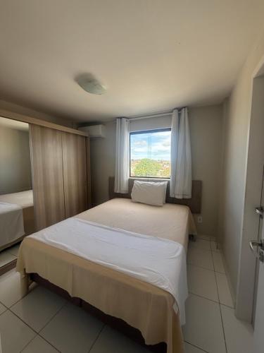 ein Schlafzimmer mit einem großen Bett und einem Fenster in der Unterkunft Novo Horizonte in Garanhuns
