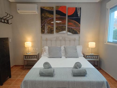 a bedroom with a large white bed with two lamps at Torremar Natura 532 in Vera