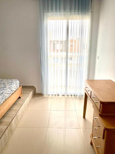 a bedroom with a bed and a dresser and a window at Duplex El mansoura A1 in Kelibia