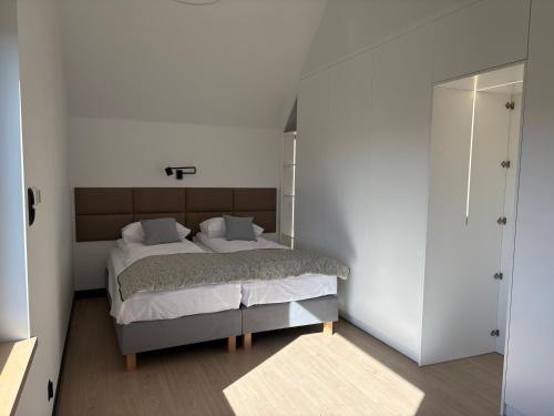 a bedroom with a bed in a white room at Dom nad jeziorem sauna balia z jacuzzi in Bogaczewo