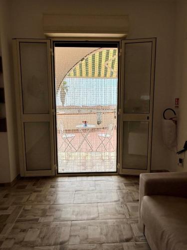 a room with a large sliding glass door with a view at Una finestra sul mare in Isola delle Femmine