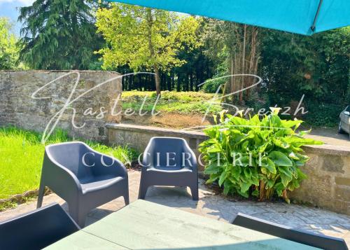 two chairs and a table in a garden at La maison de Maïe Bail in Ploumagoar