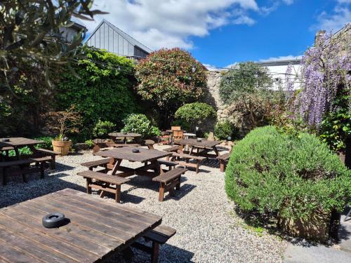 a group of wooden tables and benches in a garden at Ring O Bells in Chagford