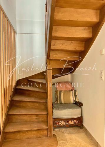 a staircase with wooden treads in a house at La maison de Maïe Bail in Ploumagoar