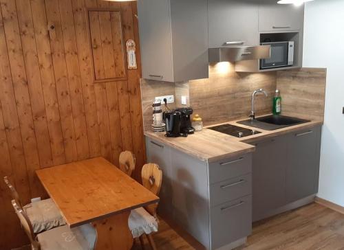 une petite cuisine avec une table et un évier dans l'établissement Studio 25m2, Lumineux - Chamonix Centre - Vue MontBlanc, à Chamonix-Mont-Blanc