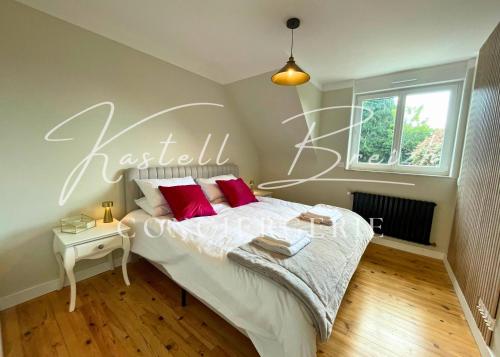 a bedroom with a bed with a heart sign on the wall at La maison de Maïe Bail in Ploumagoar