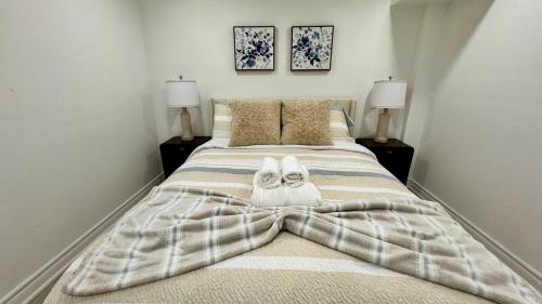 una camera da letto con un letto grande con asciugamani sopra di Cozy Hidden Gem, Stylish 2BR with Sofa Bed a Mississauga
