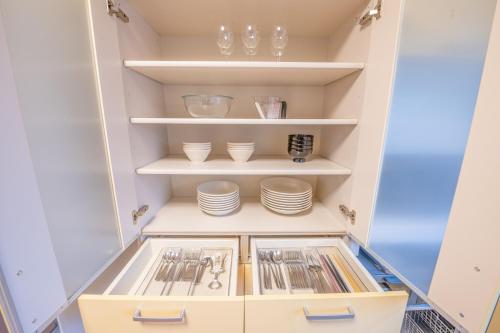 a cupboard with plates and dishes in it at House Villa Kagura in Asahikawa
