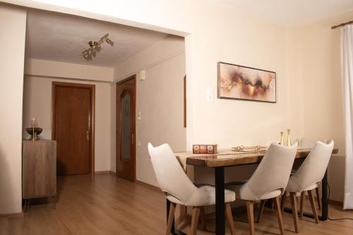a dining room with a table and white chairs at Zen Luxus Studio in Sidhirókastron