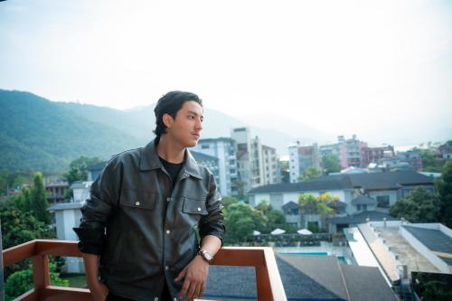 a man standing on a balcony with a city at Hotel Samip in Pokhara