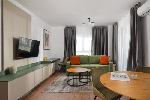 a living room with a green couch and a table at Hubix Suites - City of Mara in Timişoara