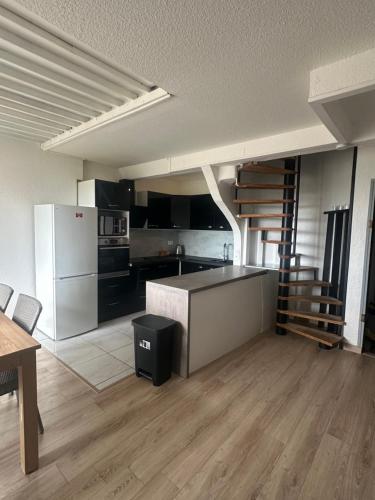 Il comprend une cuisine avec des appareils en noir et blanc et du parquet. dans l'établissement Appartement T3 60m2 avec vue sur l'Océan, à Seignosse