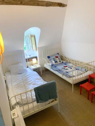 a bedroom with two beds and a mirror at Jolie maison normande ancienne in Saint-Laurent-du-Mont