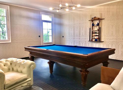 une chambre avec un billard et deux chaises dans l'établissement Villa 5 étoiles proche de Saint Émilion, à Les Artigues-de-Lussac