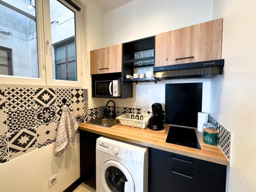 une cuisine avec un lave-linge et un sèche-linge sur un comptoir dans l'établissement Studio cosy, à Agen