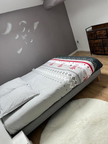 un lit dans une chambre avec un mur dans l'établissement Maison entière, à Bar-sur-Aube