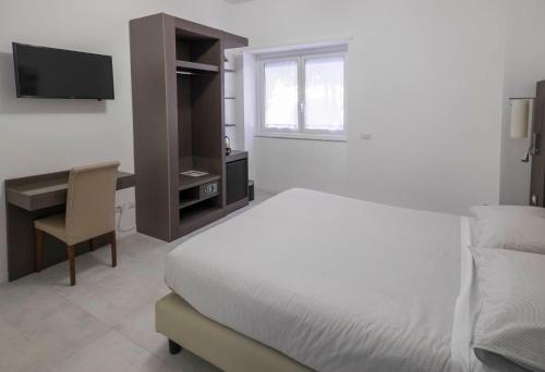 a bedroom with a bed and a desk and a television at Il Perugino Guest House in Rome