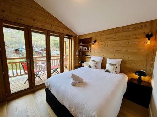 une chambre avec un grand lit et un balcon dans l'établissement Les Vernettes, 6 people, garage, Wi-Fi, à Les Deux Alpes