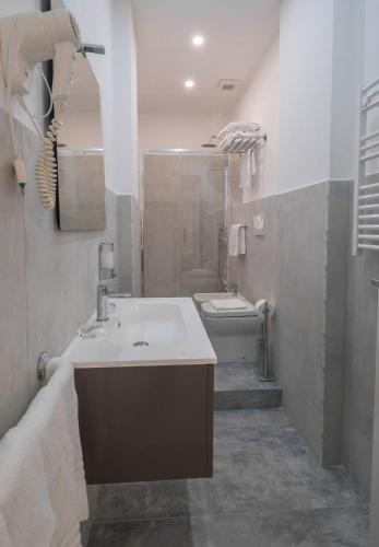 a bathroom with a sink and a shower and a toilet at Il Perugino Guest House in Rome