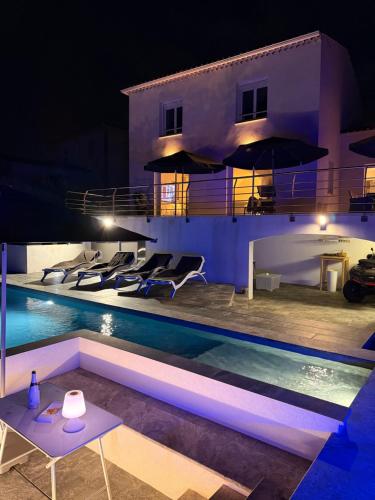 une villa avec une piscine la nuit dans l'établissement Villa Starblue 172m2 -Mer et spa, à Carry-le-Rouet