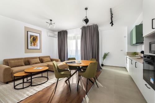 a living room with a couch and a table and chairs at Hubix Suites - City of Mara in Timişoara