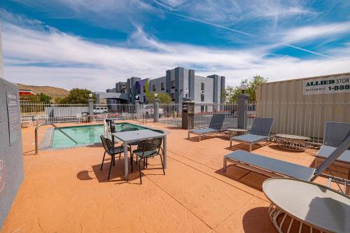 ユッカ・バレーにあるSpark by Hilton Yucca Valley Joshua Treeのパティオ(テーブル、椅子付)、プールが備わります。