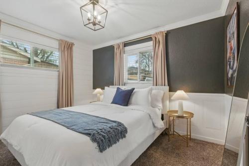a bedroom with a white bed and two windows at Projector Nights And Park Delights Designer Reno in Arvada