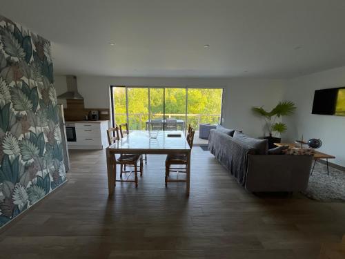 un salon avec une table et un canapé dans l'établissement Maison à la campagne, à Baguer-Pican