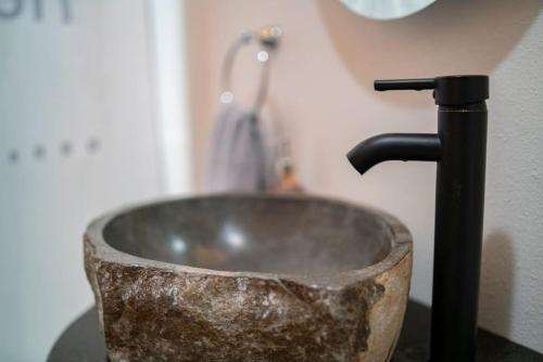 a stone sink in a bathroom with a faucet at Springs WishDowntown Historic Loop Downstairs King Free Parking in Eureka Springs