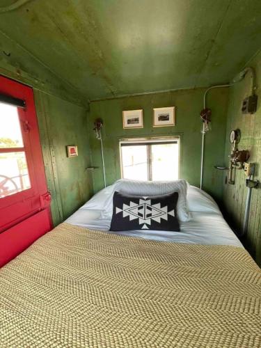 a bedroom with a bed in a green room at Midnight Train to Marfa 1948 Caboose in Marfa