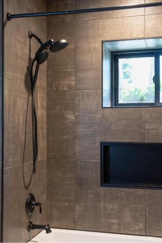 a shower with a black shower head in a bathroom at The CDA-frame - Lake Views with Boat Slip in Coeur d'Alene