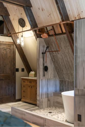 a bathroom with a wooden ceiling and a bath tub at The CDA-frame - Lake Views with Boat Slip in Coeur d'Alene