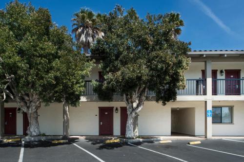 a building with trees in a parking lot at Mission Inn in Santa Cruz
