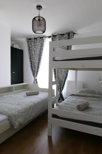 une chambre avec deux lits superposés et une fenêtre dans l'établissement Très jolie maison - Piscine & Jacuzzi - Les Sables - 9 personnes, à Les Sables-dʼOlonne