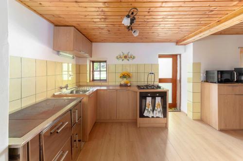 a large kitchen with wooden cabinets and a sink at Sunflower House with Jacuzzy and Sauna in Vitanje
