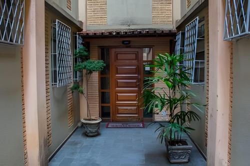 a corridor of a building with a door and plants at 4let BH Del Rey in Belo Horizonte