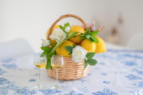 a basket of oranges and two glasses of wine at La Casa di Maddalena - Historic center VIEW in Procida