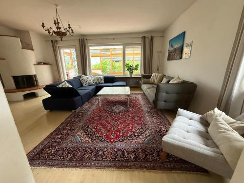 a living room with couches and a rug at Haus Freigeist in Murnau am Staffelsee