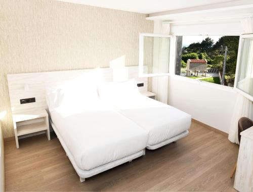 Giường trong phòng chung tại Hotel Spa Meiga do Mar