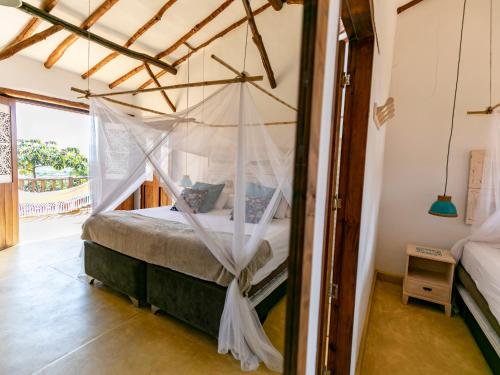 a bedroom with a bed with a mosquito net at Hotel Boutique Venturi in Barichara